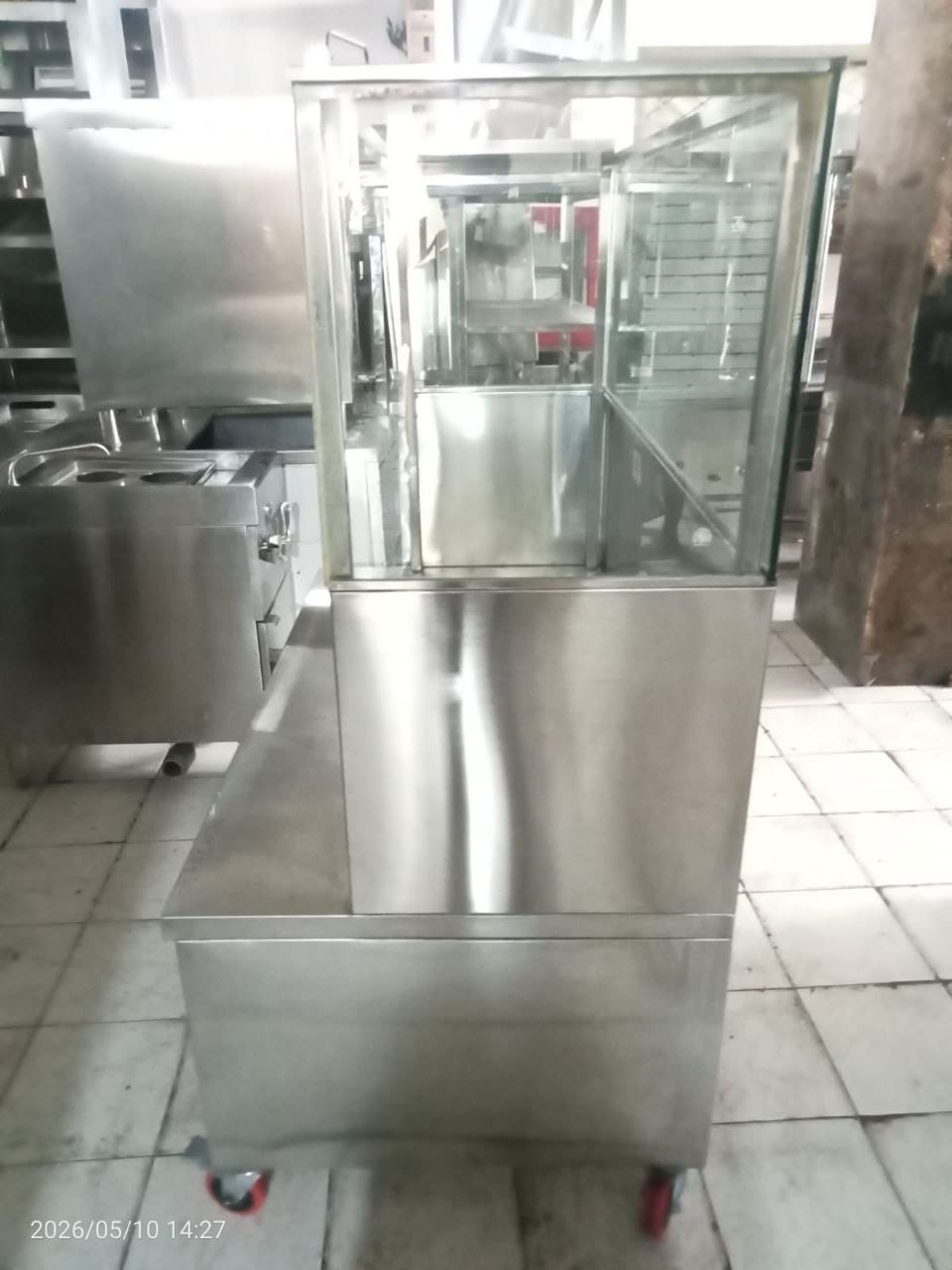 Kabinet etalase stainless steel dengan area kerja luas dan rak display untuk kebutuhan dapur profesional dan UMKM kuliner.